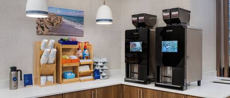 A coffee station with two coffee machines, a coffee grinder, and a sign indicating the start of the grind.