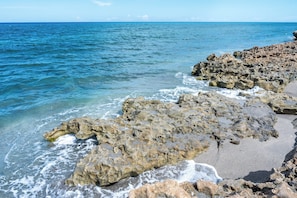 Une côte rocheuse où les vagues s’écrasent contre les rochers.