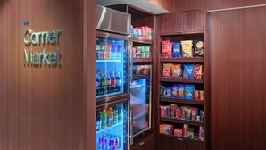 Ein Eckeladen mit Kühlregalen, gefüllt mit Getränken und Snacks.