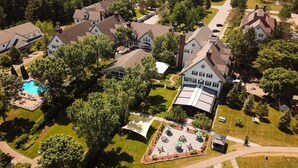 Vista aérea de una zona residencial con varias casas, una piscina y una cancha de tenis.