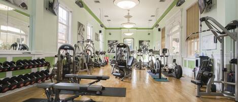A gym with various exercise equipment, including treadmills, dumbbells, and weight machines.