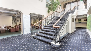 Un magnifique escalier, agrémenté de rampes richement décorées, menant à un deuxième étage.