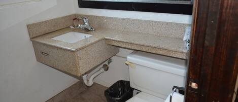 A small bathroom with a sink, toilet, and mirror.