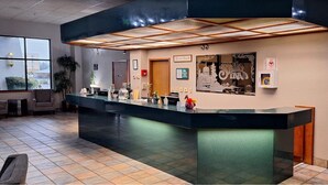 A reception area with a modern counter, a large window, and a wall-mounted sign. - Shilo Inn Suites - Salem (Salem)