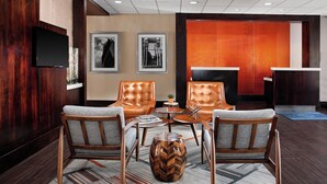 A lobby with leather armchairs, a wooden coffee table, and a herringbone-patterned side table. - Four Points by Sheraton Memphis East (Memphis)
