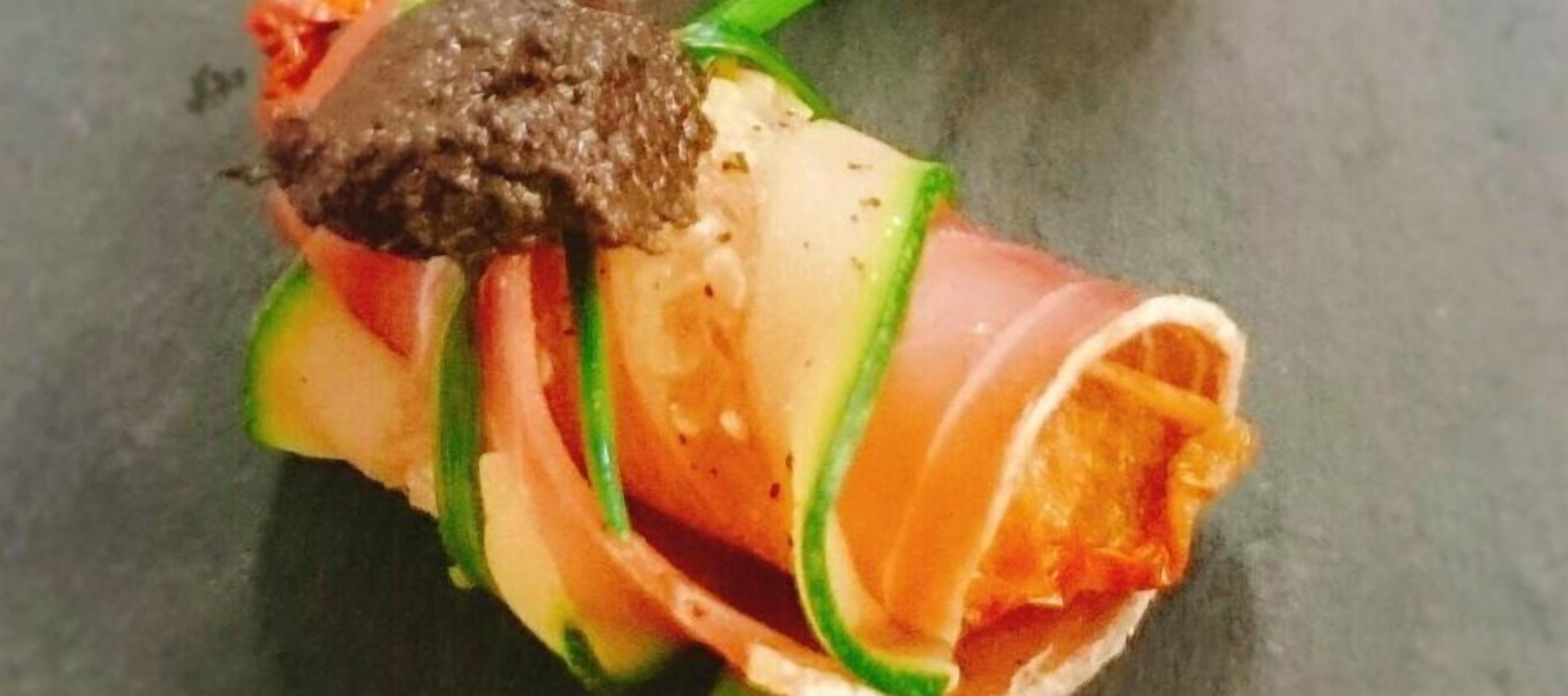 A dish with sliced vegetables and a dark sauce.