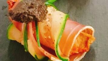 A dish with sliced vegetables and a dark sauce.