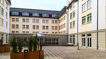 Ein Innenhof mit einer zentralen Sitzgruppe, umgeben von mehrstöckigen Gebäuden mit großen Fenstern und modernem Design.