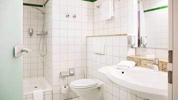 Une salle de bain équipée d’une baignoire, de toilettes, d’un lavabo et d’un miroir.