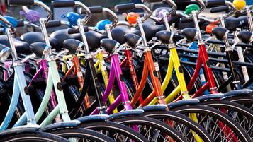 A row of bicycles with various colors and designs, parked closely together.