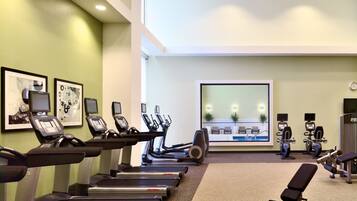 A gym with treadmills, exercise bikes, and weight machines.
