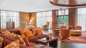 Un vaste espace de vie comprenant un grand canapé, une table basse et un coin salon avec des fauteuils.