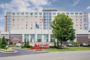 Un hotel Marriott con una fachada moderna, varios pisos y una entrada amplia.