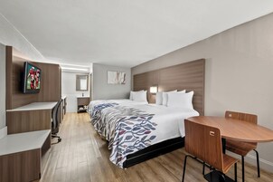 Una habitación de hotel moderna con una cama grande, un escritorio y una mesa de comedor.