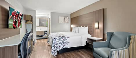 A modern hotel room with a bed, a desk, a chair, and a TV.