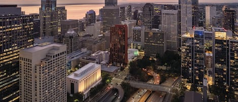 A cityscape with high-rise buildings, a waterfront, and a busy highway.
