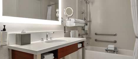 Un baño moderno con dos lavamanos, un espejo grande, ducha y bañera.