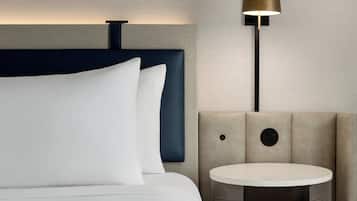 Ein modernes Hotelzimmer mit einem Bett, einem runden Tisch und einer Lampe.
