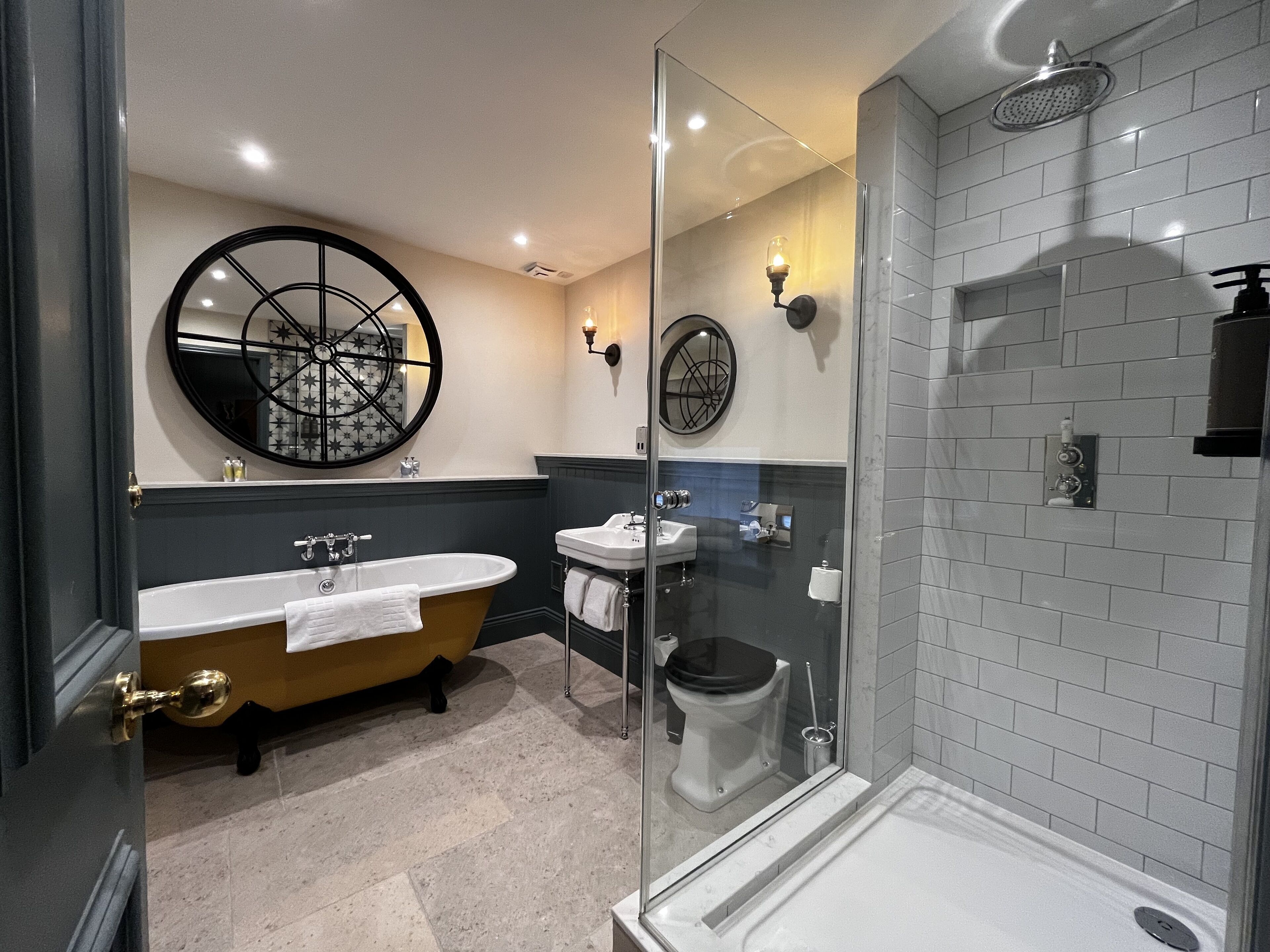 Et moderne badeværelse med et fritstående badekar, toilet og en bruseområde med glasvægge.