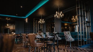 A restaurant interior with wooden flooring, tables, chairs, and hanging chandeliers. - Blackwell Grange Hotel (Darlington)