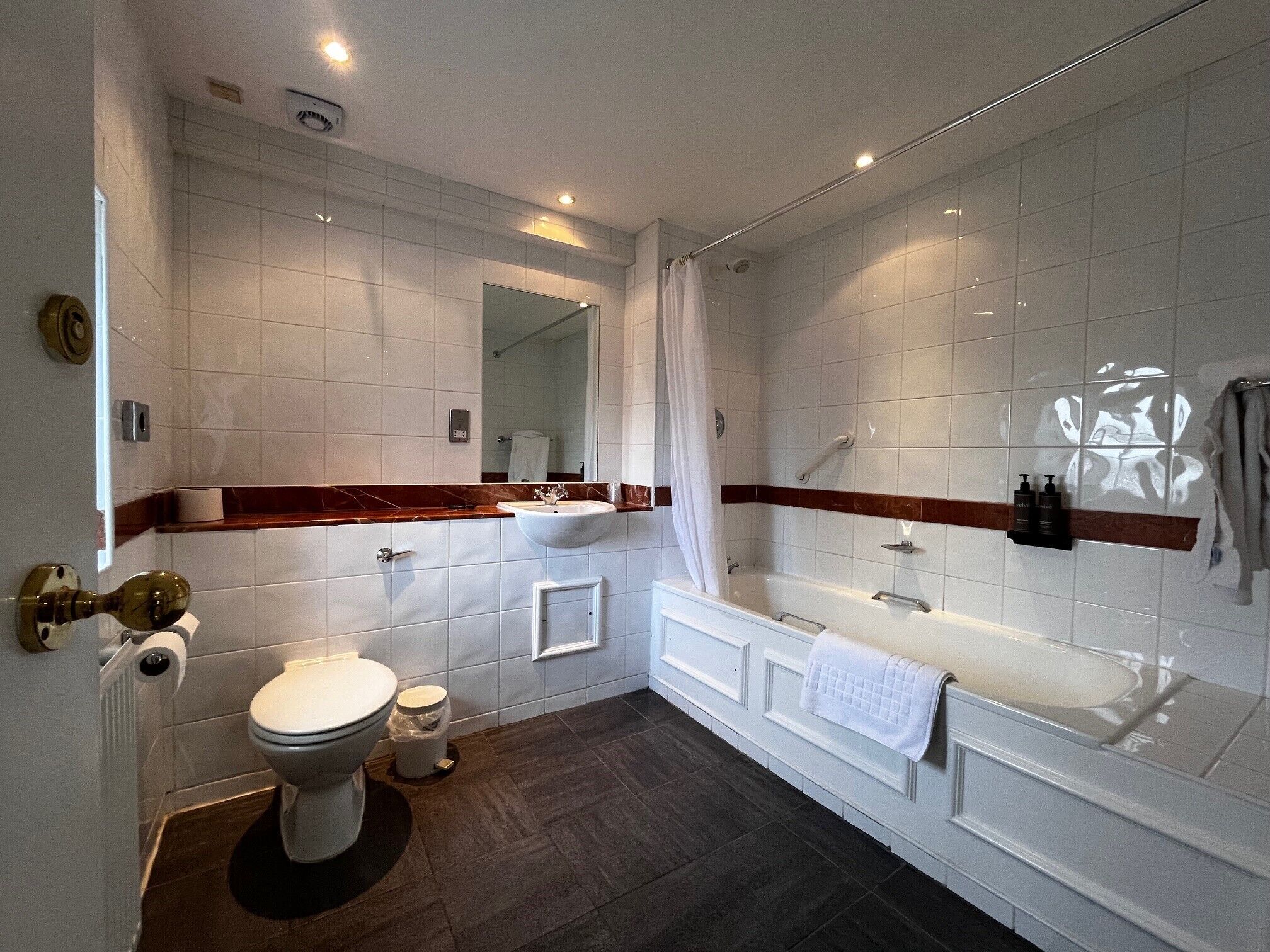 A modern bathroom with a toilet, sink, bathtub, and shower.