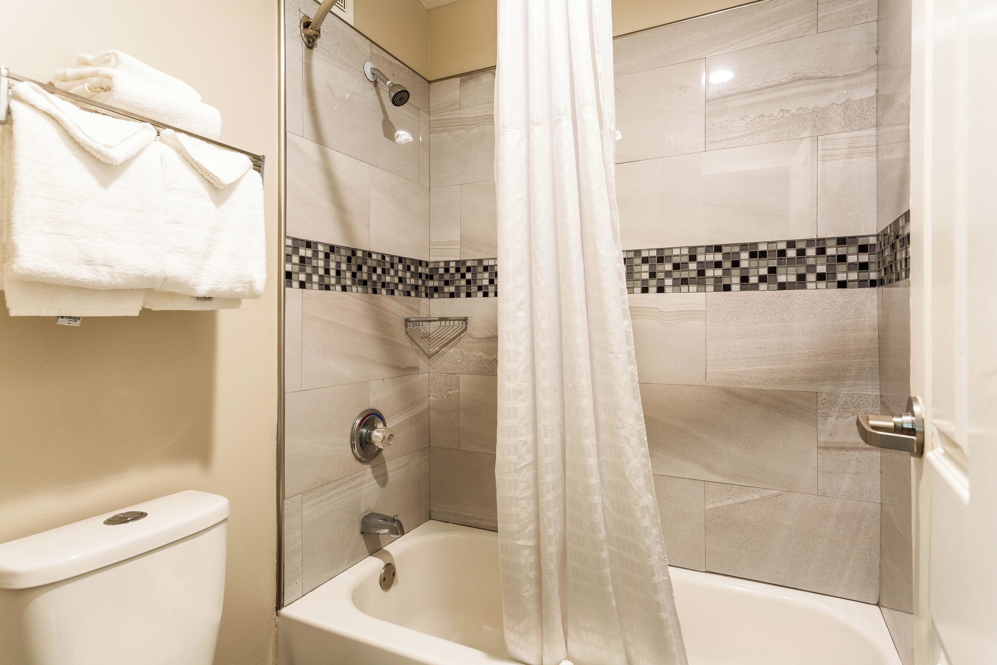 Un baño con bañera, ducha e inodoro.