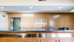A reception desk with a sign reading "Econo Lodge" and a digital display.
