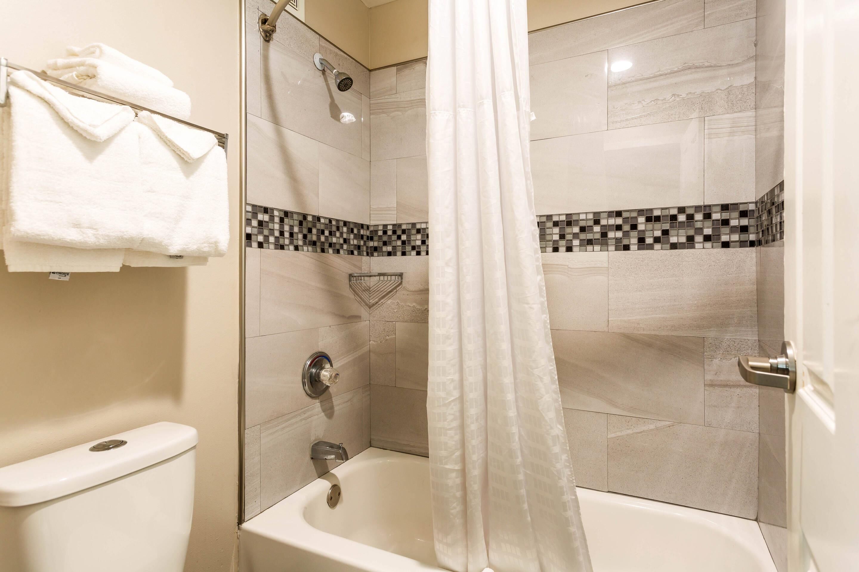 Un baño con bañera, ducha e inodoro.