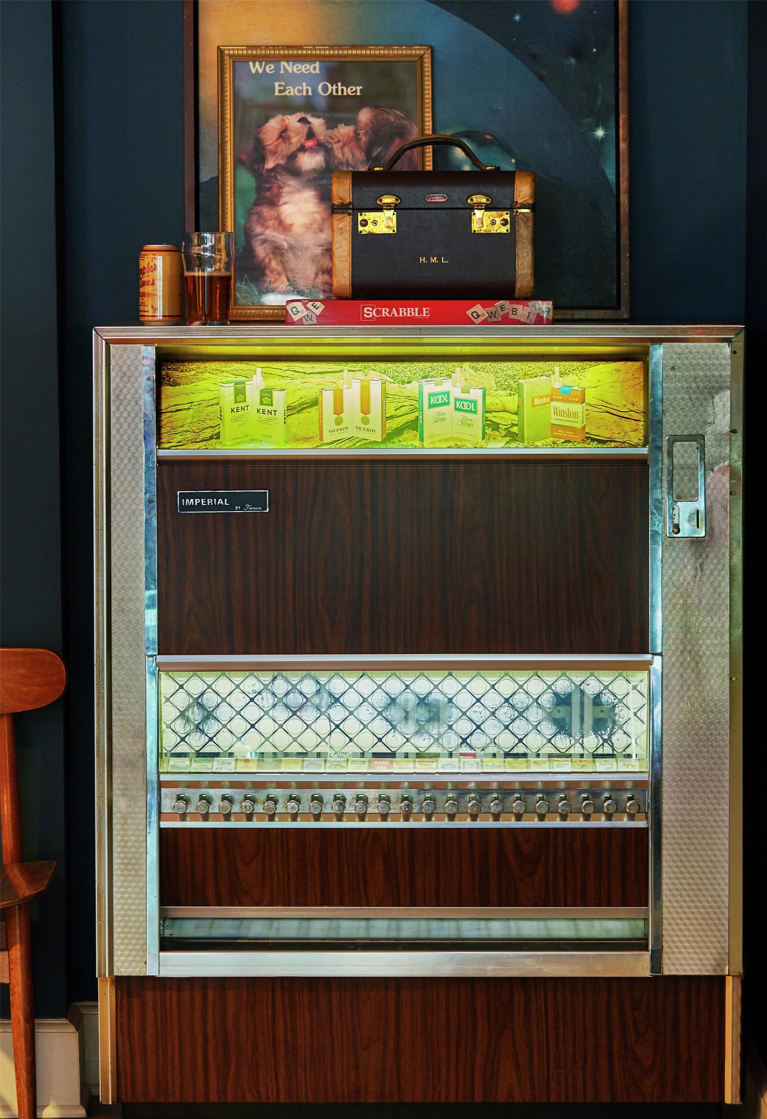 A vintage vending machine with a wooden exterior, a glass display for beverages, and a sign above it.