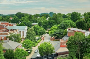 A town with a prominent red-brick building labeled "Chancellors Drug Store" and a road leading through a green, tree-lined area.