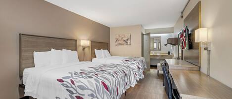Une chambre d’hôtel avec un grand lit, un bureau et un miroir.