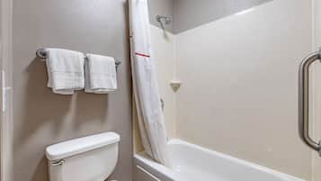 Un baño con inodoro, bañera y cortina de ducha.