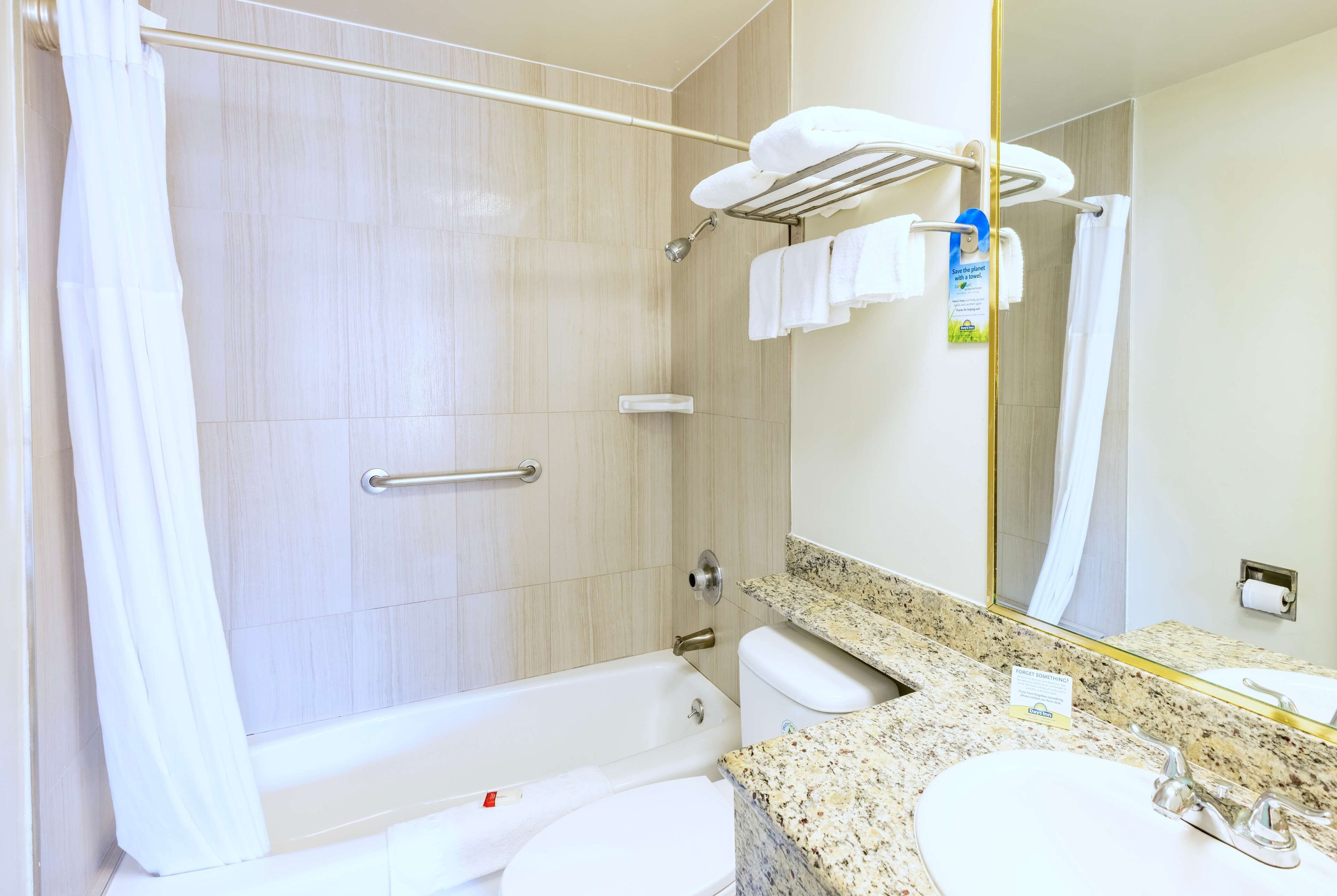 A bathroom with a bathtub, toilet, sink, and a shower area.