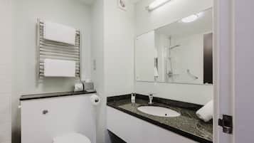 A modern bathroom with a toilet, sink, and mirror.