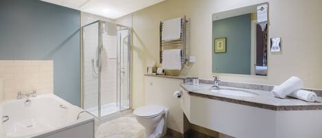 A modern bathroom with a bathtub, shower, toilet, and vanity.