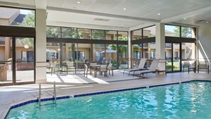 A pool area with lounge chairs and a view of the surrounding buildings. - Courtyard by Marriott Detroit Dearborn (Dearborn)