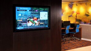 A digital display in a hotel lobby with a map, news, and stock market information. - Courtyard by Marriott Detroit Dearborn (Dearborn)