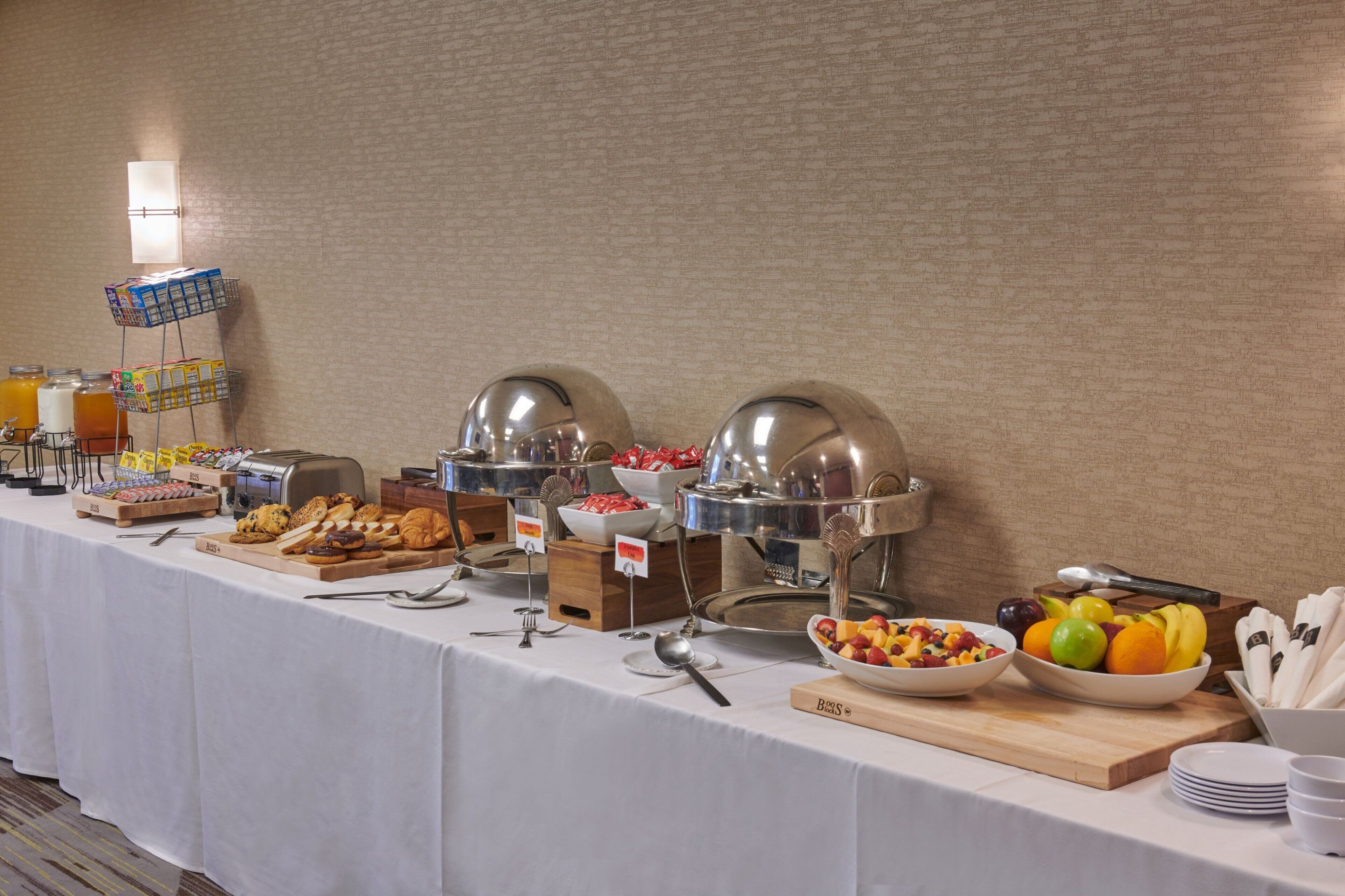 A buffet setup with various food items and utensils.