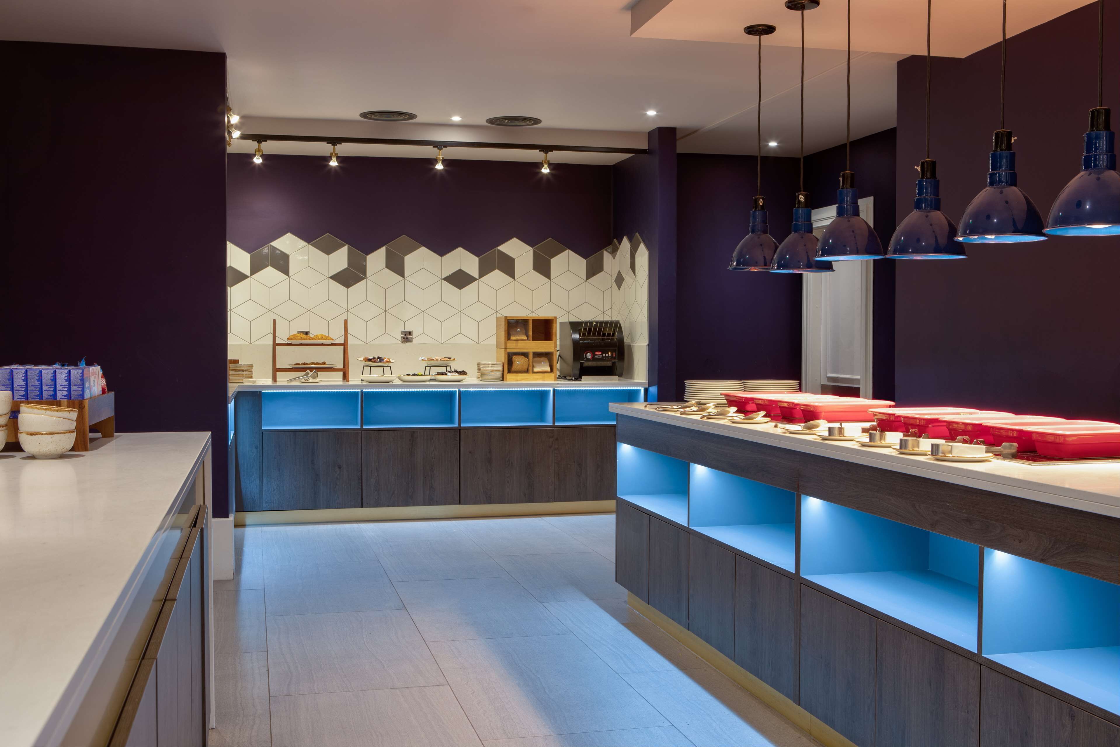 A modern kitchen with a central island, built-in appliances, and pendant lighting.