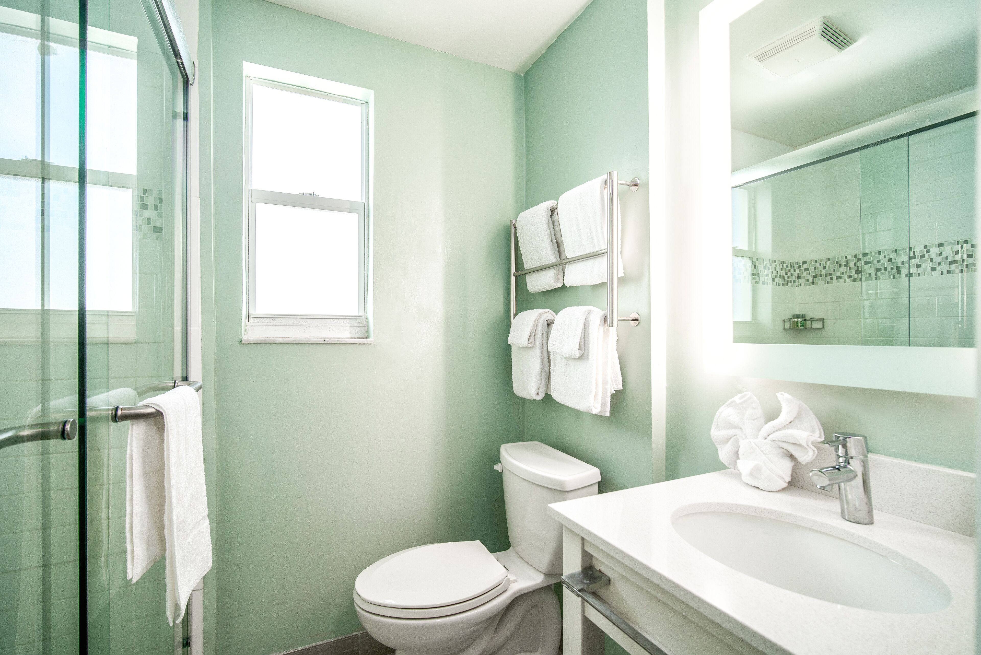 A bathroom with a toilet, a sink, and a glass shower enclosure.