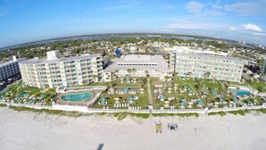 Un grand complexe hôtelier comprenant plusieurs b âtiments, une piscine centrale et un espace de plage.