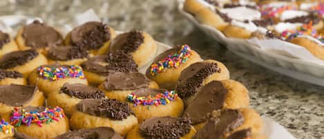 A tray of assorted doughnuts with chocolate frosting and sprinkles.