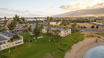 Un resort con diversi edifici, un prato curato e spiaggia.