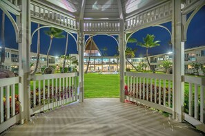 Un espacio al aire libre techado con vistas a un edificio y un jardín.