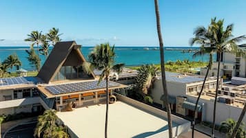 A resort with a rooftop pool, solar panels, and a view of the ocean.