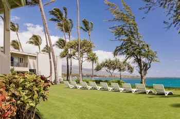 A modern lounge area with sofas, a wooden coffee table, and a pool table. at Maui Beach Hotel