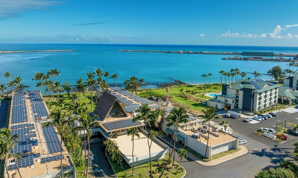 A resort with multiple buildings, solar panels, and a view of the ocean.