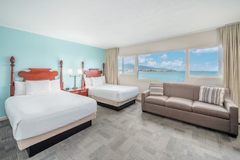 A kitchen with a view of the ocean, a ceiling fan, and a coffee maker. at Maui Beach Hotel