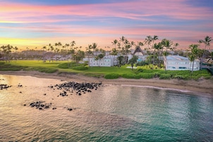 Un resort con alojamiento frente a la playa, campo de golf y palmeras.