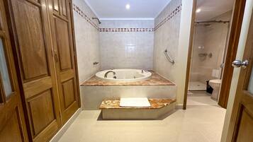 Un baño con bañera independiente, zona de ducha y retrete.